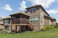 Three-storey beautiful expensive house surrounded by green manicured lawn and bushes