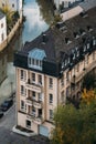 Three-story building with pink facade and dark roof on riverbank Royalty Free Stock Photo