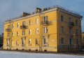 Three-story yellow residential building in the city