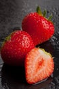 Three strawberries on black with water drops Royalty Free Stock Photo