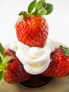Three strawberries and cream on a plate Royalty Free Stock Photo