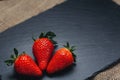 Three strawberries on gray stone. Three strawberries on a gray stone background Royalty Free Stock Photo