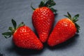 Three strawberries on gray stone. Three strawberries on a gray stone background Royalty Free Stock Photo