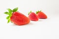 Three strawberries with green leaves stacked diagonally Royalty Free Stock Photo
