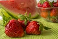 Three strawberries in Huelva on a green tablecloth.