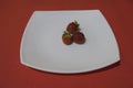 Three strawberries lie on a plate Royalty Free Stock Photo