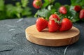 Three Strawberries on a Wooden Plate on a Table Royalty Free Stock Photo