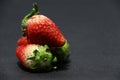 Three Strawberry on the black floor.