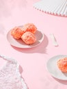 Three strawberry snowballs in a porcelain bowl and single one served in white plate on a pink table Royalty Free Stock Photo
