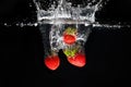 Three strawberrys splashing into water