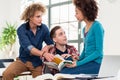 Three students comparing information from two different textbook Royalty Free Stock Photo