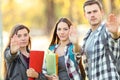 Three students gesturing stop in a park