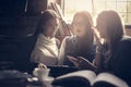 Three students girl learning together and using smart phone. Royalty Free Stock Photo