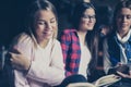 Three students girls sitting in library and learning together. Royalty Free Stock Photo