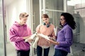 Three students standing near glass doors and revising material Royalty Free Stock Photo