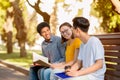 Three Students Talking Discussing Classes Relaxing Sitting On Bench Outdoors Royalty Free Stock Photo