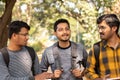 Three students talking or socializing at university campus - Friends having fun and conversation at college - concept of Royalty Free Stock Photo