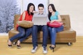 Three students using laptop in the couch Royalty Free Stock Photo