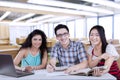 Three students writing in the class