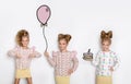 Three stunning beautiful little girls with long blond hair standing on a white background and one of them holds a balloon, the sec Royalty Free Stock Photo