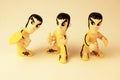 Three stylised Bruce Lee toys in the famous yellow tracksuit