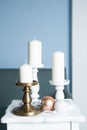 Three Stylish white large candles on the table, and New Year`s balls, photos in gentle pastel colors. Christmas mood Royalty Free Stock Photo