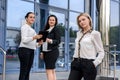 Three successful business ladies standing in front of central entrance of office Royalty Free Stock Photo