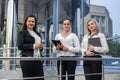 Three successful business ladies standing in front of central entrance of office Royalty Free Stock Photo