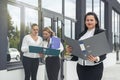 Three successful business ladies standing in front of central entrance of office Royalty Free Stock Photo