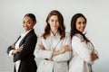 Three successful multicultural businesswomen standing with arms crossed and smiling at camera, posing in office Royalty Free Stock Photo