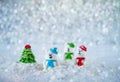 Three sugar candy bears in the snow on bokeh background with copy space for season greeting Merry Christmas or Happy New Year Royalty Free Stock Photo