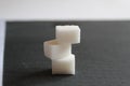 three sugar cubes are stacked on top of each other or in a pyramid on a white gray and black background with space for inserting t Royalty Free Stock Photo