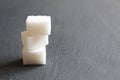 Three sugar cubes are stacked on top of each other or in a pyramid on a white gray and black background with space for inserting t Royalty Free Stock Photo