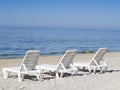 Three sun loungers on a deserted beach