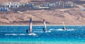 Three surfers compete in the Red Sea in the lagoon in Egypt Dahab Royalty Free Stock Photo