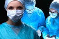 Three surgeons at work operating in surgical theater saving patient and looking at life monitor. Resuscitation medicine