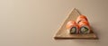Three Sushi Rolls Placed at the Points of an Equilateral Triangle on a Muted Taupe Background Royalty Free Stock Photo
