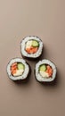 Three Sushi Rolls Placed at the Points of an Equilateral Triangle on a Muted Taupe Background Royalty Free Stock Photo