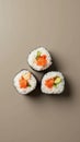 Three Sushi Rolls Placed at the Points of an Equilateral Triangle on a Muted Taupe Background Royalty Free Stock Photo