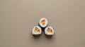 Three Sushi Rolls Placed at the Points of an Equilateral Triangle on a Muted Taupe Background Royalty Free Stock Photo