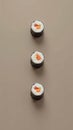 Three Sushi Rolls Placed at the Points of an Equilateral Triangle on a Muted Taupe Background Royalty Free Stock Photo