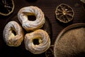 Three sweet cream puffs on dark board with cinnamon sugar in bowl Royalty Free Stock Photo