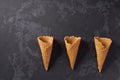 Three sweet wafer cones on a black background