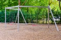 Three swings with metal chains and poles on a public playground Royalty Free Stock Photo