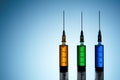 Three syringes filled with colorful liquids Royalty Free Stock Photo