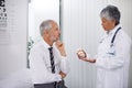 Three tablets, twice a day. A mature doctor giving a bottle of pills to one of her patients during a checkup. Royalty Free Stock Photo