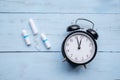 Three tampons with alarm clock on the table