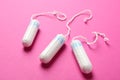 Three tampons on pink background