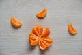 Three tangerine orange slices on the gray wooden board with free copy space. Fresh raw mandarin orange and peeled yellow tangerine
