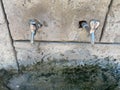 Three taps from which water flows. The water is clean and clear for drinking. Cranes made in a stone wall Royalty Free Stock Photo